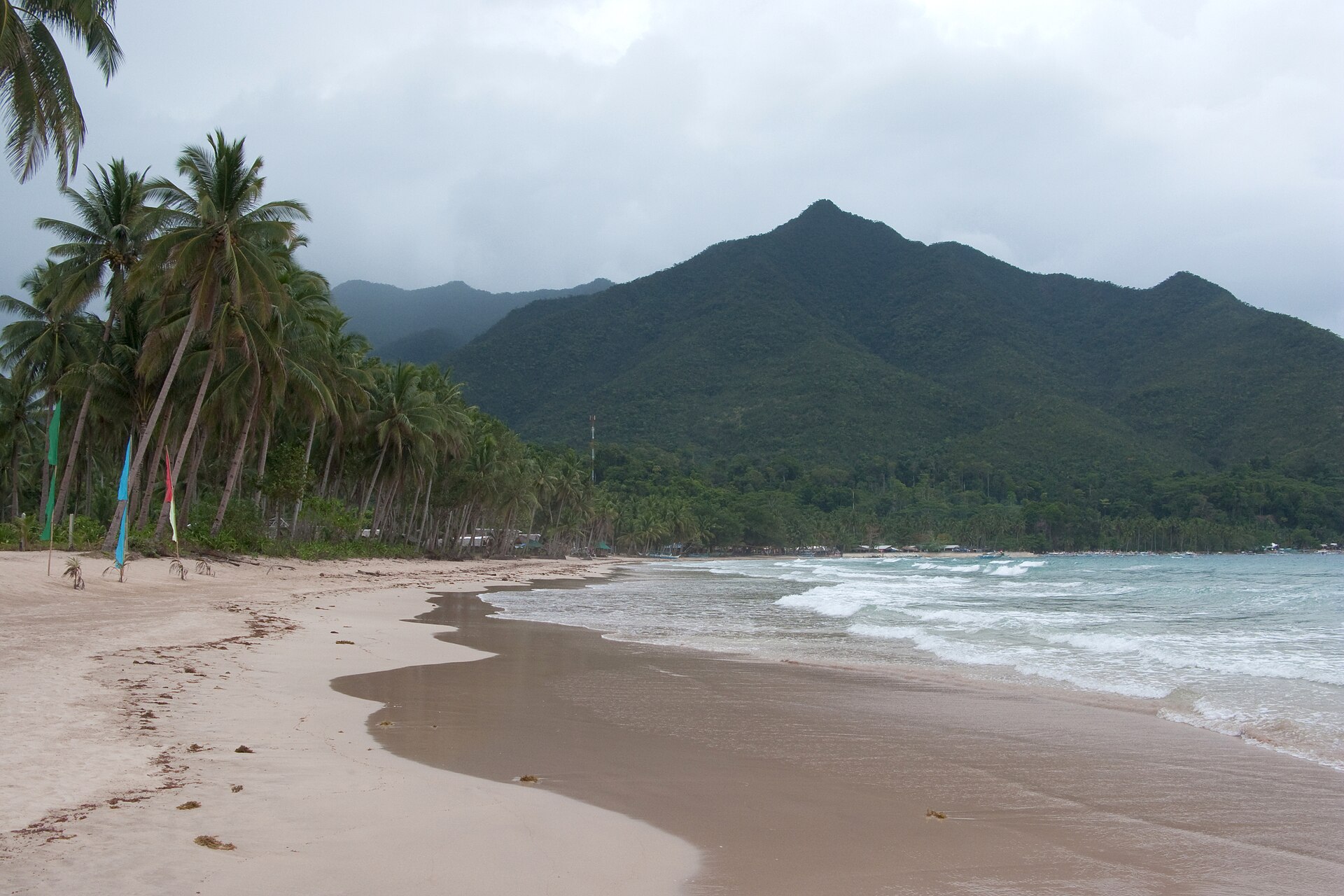 Sabang Beach and the forested mountain backdrop on Palawan Island.